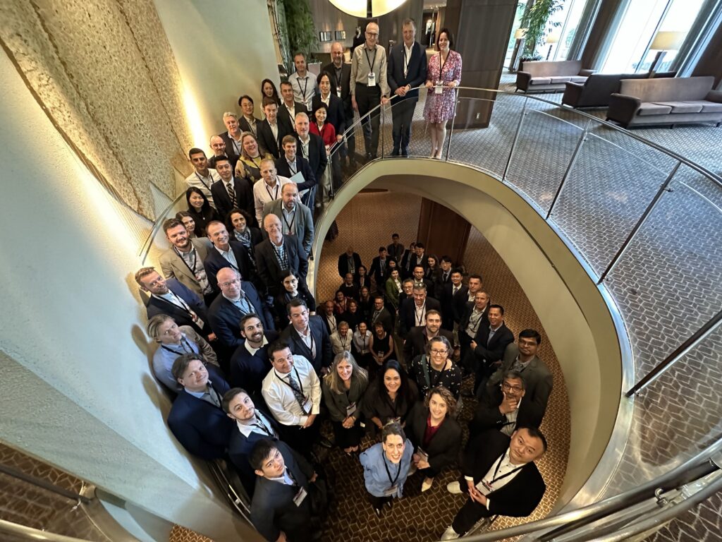 A large number of people, organization membrs, gathered on a big spiral staircase.